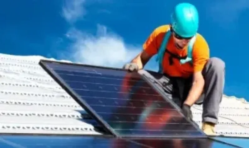 Instalador fixando um painel solar sobre o telhado (imagem do material do fabricante)